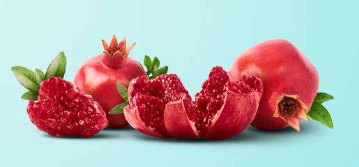 Fresh ripe pomegranate with green leaves isolated on white background.