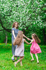 Family in blooming apple blossom garden.