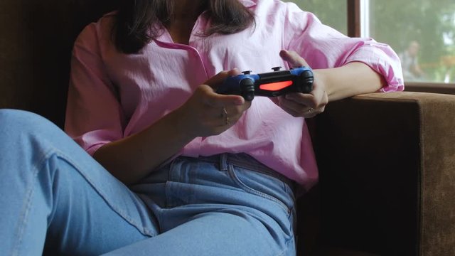Woman playing video game on sofa
