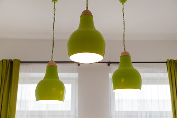 Obraz premium Three ceiling green lamps in white interior