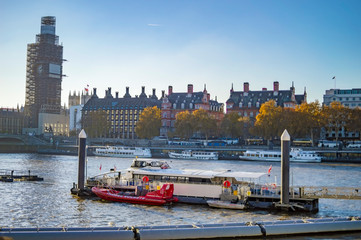 Thames river cruises and boats in the water and across the bridge big ben and parliaments are also...