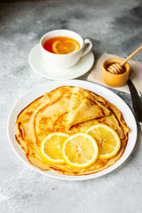 Food, dessert, pastries, pancake, pie. Tasty beautiful pancakes with banana and honey on a concrete background