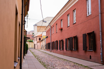 Fototapeta na wymiar Pedestrian street in the old town of Vilnius, capital of Lithuania, with Gates of Dawn, orthodox monastery and catholic church