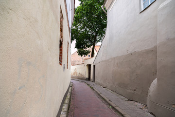 Pedestrian street in the old town of Vilnius, capital of Lithuania, with Gates of Dawn, orthodox monastery and catholic church