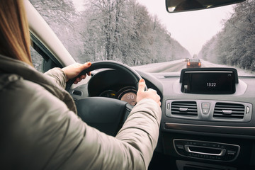 Woman driving the car on snowy road