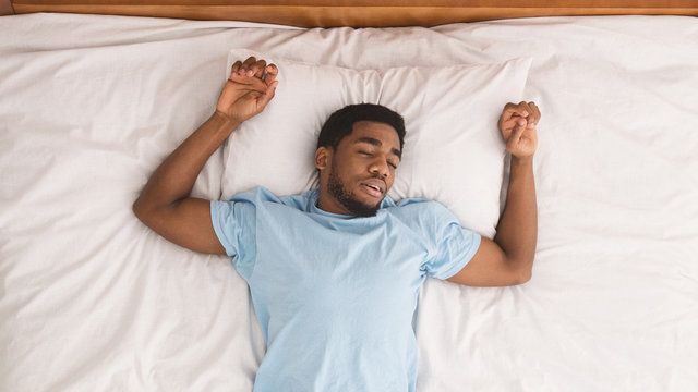 Young African-american Man Sleeping In Bed Top View