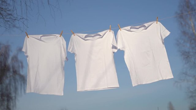 T-shirts hanging on the clothesline against blue sky