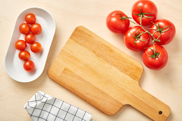Raw tomato on table with chopping board and textile napkin. 