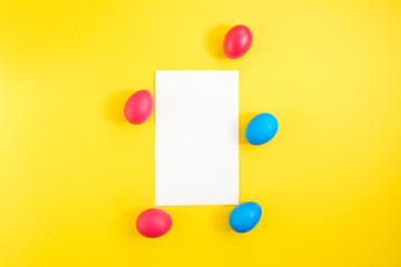 The frame of the creative layout of eggs painted red and blue colors on a yellow background