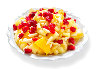 Fruit salad with pomegranate seeds, isolated on white