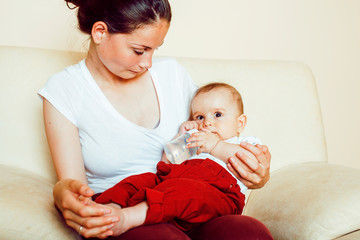 young brunette happy mother holding toddler baby son, breast-feeding concept, lifestyle modern people kissing
