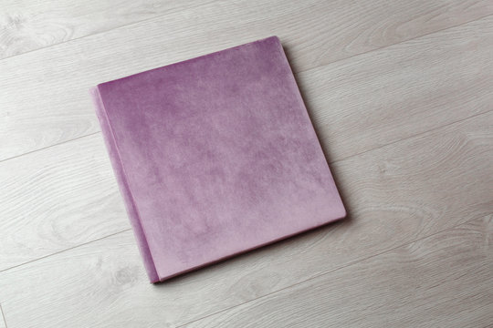 family photo book . Photobook on a light background with space for text. Pink  Photo album with a hard cover on a wooden background . Bright  photoalbum.