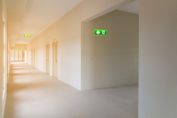 green emergency exit sign to install in new hospital building construction showing the way to escape