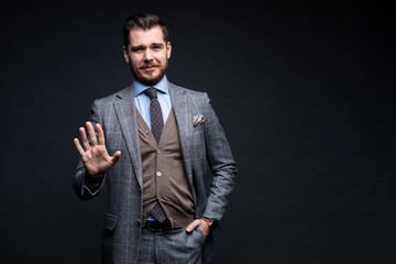 Portrait of excited satisfied cheerful confident positive handsome demonstrating thumbs-up pointing up isolated on black background.