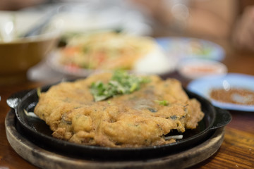Oyster omelette or Thai-style fried mussels in a hot pan.