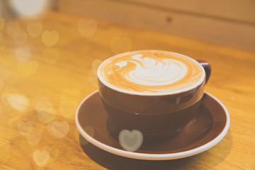 Latte hot coffee with late art in cup on wood table