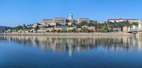 Fototapeta na wymiar Budapest, Hungary. Panoramic view of Castle Hill with Royal Palace, Castle Garden, Sandor Palace, Castle Hill Funicular and fragment of Szechenyi Chain Bridge. View from Danube in the morning.