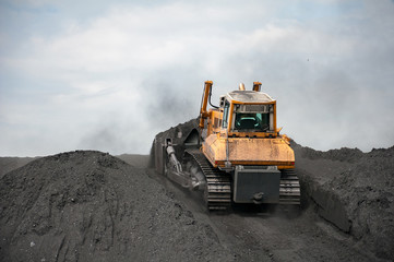 caterpillar tractor and travelling crane load black coal on supply field of thermoelectric power station © sashagrunge
