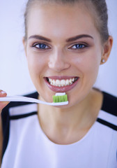 Young pretty girl maintaining oral hygiene with toothbrush.