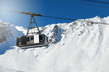 Fototapeta na wymiar big cable car on snowy winter mountain background in ski resort