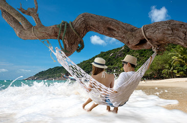 couple lover in romantic on the hammock hang on the tree ont the sea beach, enjoy and happy on...