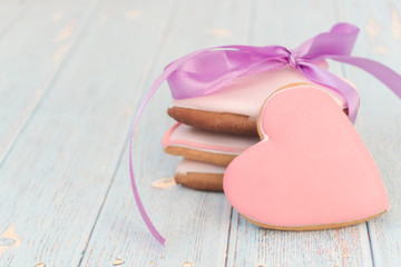 Painted gingerbread on a light wooden background. There is for text. Love concept