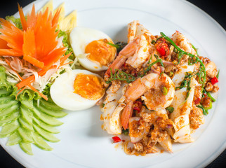 Spicy and sour seafood salad mixed with vegetables,  Thai herbs and boiled eggs ,shrimp,squid in Thai style