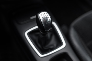 Black interior of a modern car, six-speed manual shift car gear lever.