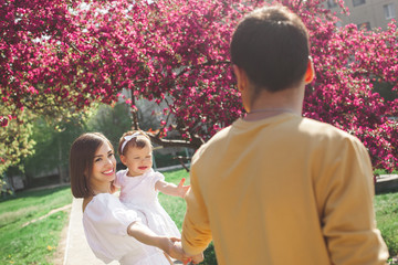 Young family walking outdoor. Happy family together walking by the hand.