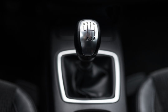Black interior of a modern car, six-speed manual shift car gear lever.