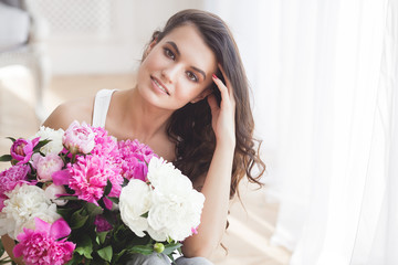 Beautiful woman holding flowers. Young lady with peony