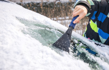Scraping ice from the car window