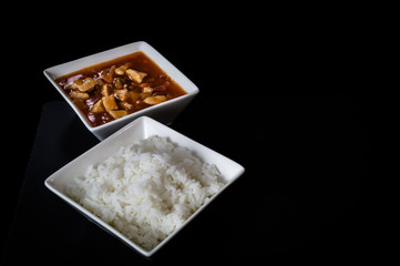 Beautiful image of chinese rice with sauce. White plate and black background.