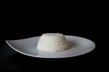 Beautiful image of chinese rice on a white plate and black background.