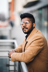 Naklejka premium Portrait of indian bearded businessman standing outdoors in front of business center