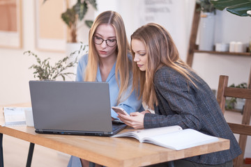 two girls are bloggers live for subscribers. young women shoot or edit video for a video channel. online business