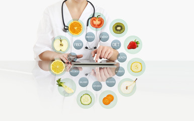 hands of nutritionist doctor touch digital tablet at office desk with symbols fruits icons isolated...