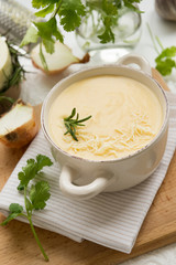Obraz na płótnie Canvas Cheese soup with yellow and white cheese, cream, onions and potatoes