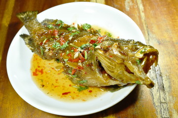 deep fried red banded grouper fish dressing sweet chili sauce on plate