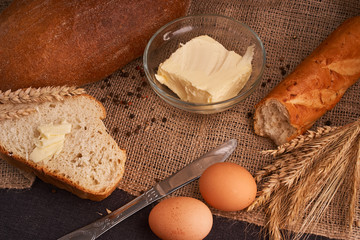 Different bread and wheat on the rustic table. Selective focus, close up