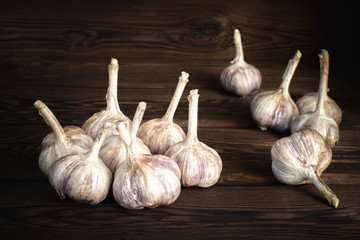 a lot of farm fresh garlic on a wooden background