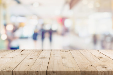 Empty wood table and People in shopping in department store. Defocused blur background, display montage for product with copy space.