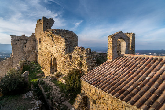 View of Palafolls castle medieval ruined stronghold between Girona and Barcelona on the Costa Brava with the Catalan flag proudly flying over the Romanesque church