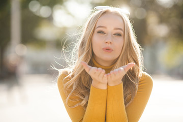 Closeup portrait of young attractive woman outdoors with copy space. Beautiful blond girl model. Cheerful lady on neutral background spring, fall, autumn.