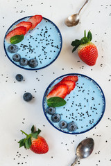 Blue yogurt smoothie made with blue spirulina powder, strawberries and blueberries.