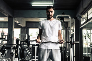 Fototapeta na wymiar Handsome man is rowing exercise with bodybuilder equipment in fitness club.,Portrait of strong man doing working out calories burning in gym., Healthy and fitness sport gym concept.