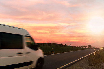 Lieferwagen auf Landstraße im Sonnenuntergang