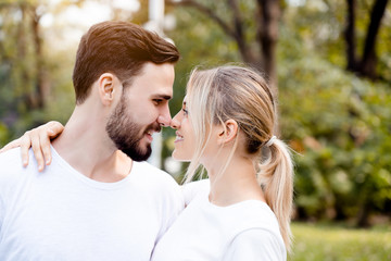 Closeup at the head of a lover, a man and a woman standing facing the nose, colliding And hugging in the garden In good weather in the morning of summer With fresh breath from good oral health care