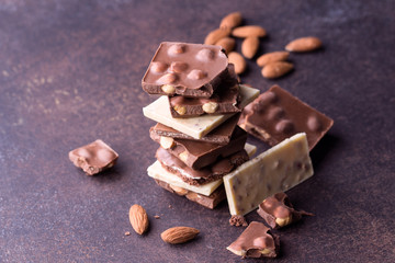 Dark chocolate stack and almond on dark background