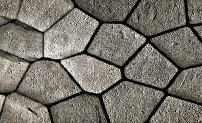 Rough gray stone wall texture. An abstract illustration of a cobblestone stonework. Black joints at the junction of parts. Potholes, scratches, patina on a textural background. Digital art in vintage